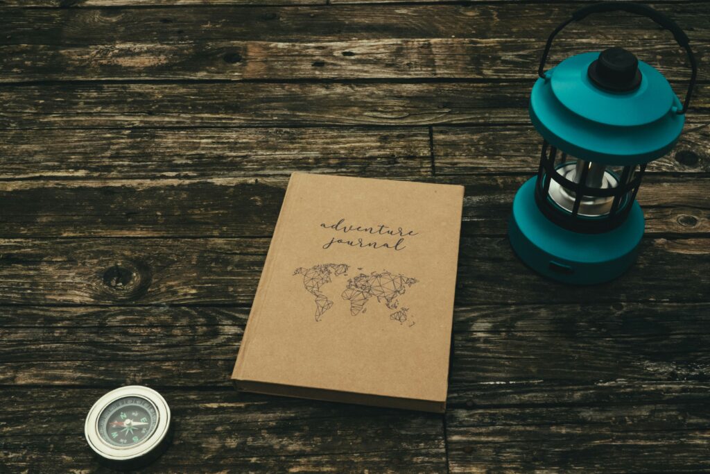 journal, compass, and camping lamp